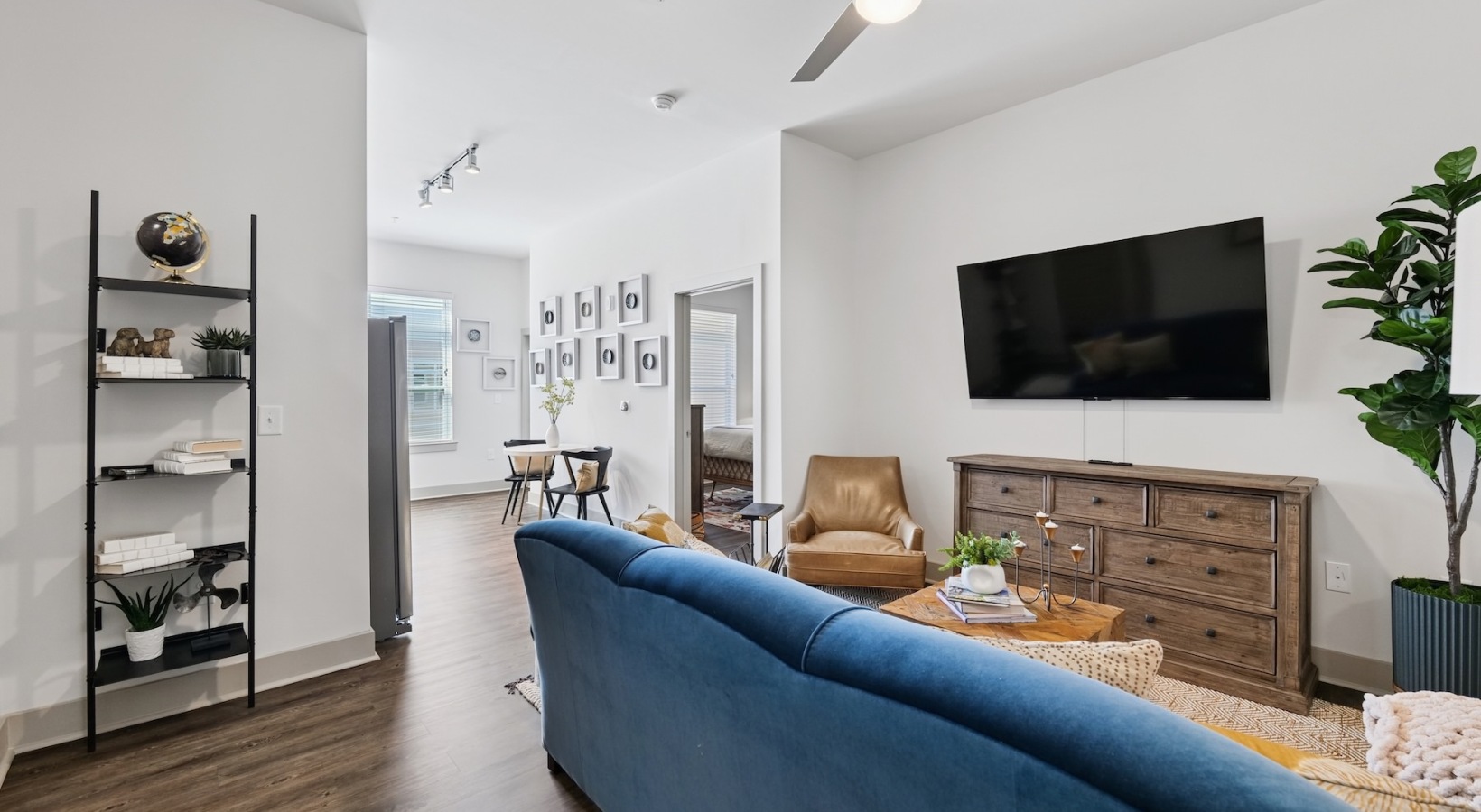 Spacious living areas to recline and recharge living room with blue couch and ceiling fan